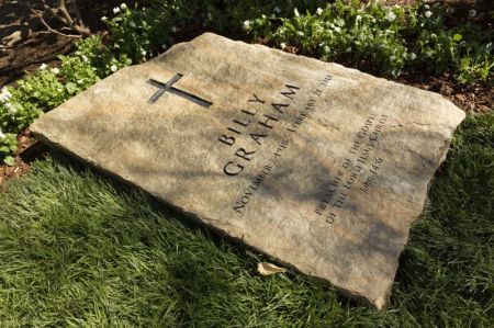 A slab of North Carolina stone marks the grave of Billy Graham, buried next to his wife, Ruth, at the Prayer Garden located next to the Billy Graham Library in Charlotte. The marker inscription bears the text, "Preacher of the Gospel of the Lord Jesus Christ" with the Scripture reference, John 14:6.
