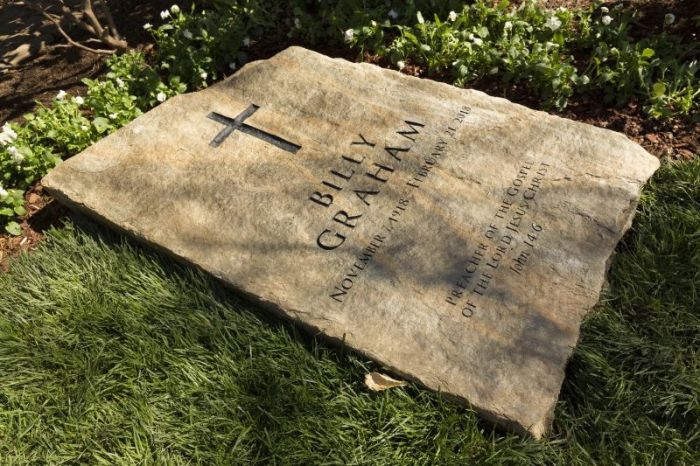 A slab of North Carolina stone marks the grave of Billy Graham, buried next to his wife, Ruth, at the Prayer Garden located next to the Billy Graham Library in Charlotte. The marker inscription bears the text, 'Preacher of the Gospel of the Lord Jesus Christ' with the Scripture reference, John 14:6.