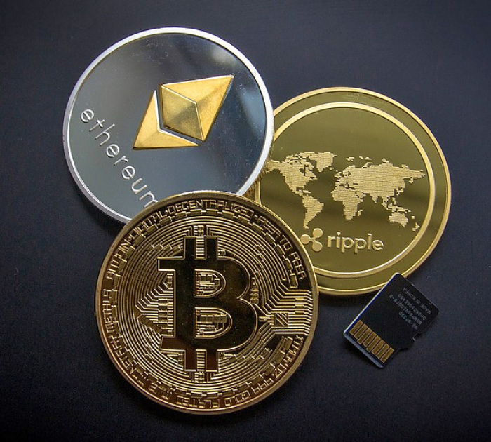 An illustration photo of several popular cryptocurrencies here, as represented by physical coins, from the top clockwise: ethereum, ripple and bitcoin.