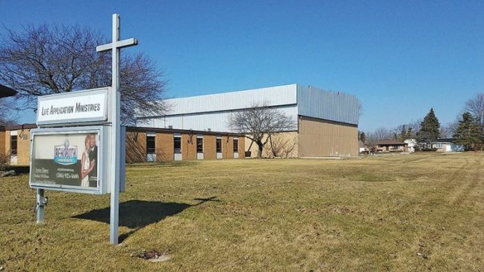 The incomplete youth activity center can be seen behind the Life Application Ministries church building here.