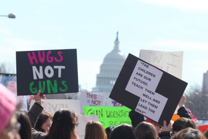 Demonstrators in the March for Our Lives hold up signs as the march toward the United States Capitol Building in Washington, D.C. on March 24, 2018.