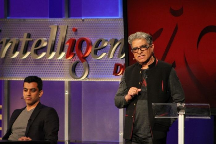 World-renowned pioneer in integrative medicine and personal transformation Dr. Deepak Chopra (R) argues why God is necessary at an Intelligence Squared debate in New York City on March 27, 2018. His debate partner, Dr. Anoop Kumar (L), listens intently.