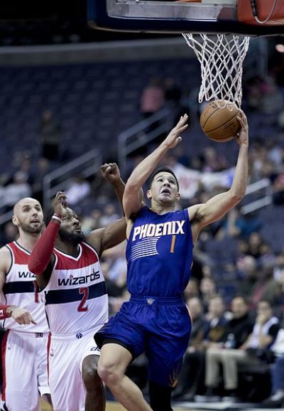 Devin Booker driving to the basket in a game against the Washington Wizards. Both the Wizards and the Suns are part of the NBA 'bubble community'