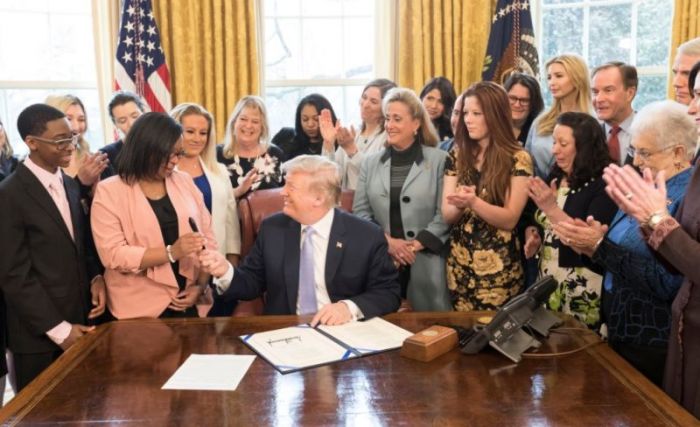 President Donald Trump hands away the pen he used to sign the Fight Online Sex Trafficking Act into law, on Wednesday, April 11, 2018.
