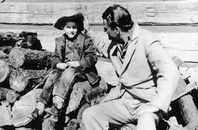 A 1958 photo of the Reverend Billy Graham (right) with his son Franklin Graham (left) sitting on a woodpile.
