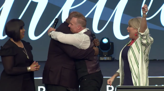Pastor Ron Carpenter (center right) hugs John Gray, who is now the new pastor of Redemption Church (now named Relentless Church) in South Carolina, May 6, 2018.