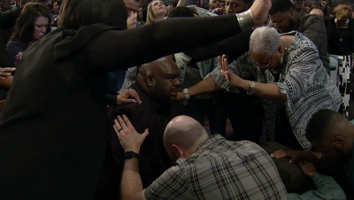 People lay hands on John Gray, the new lead pastor at Redemption Church (now Relentless Church) in South Carolina, during Sunday service on May 6, 2018.