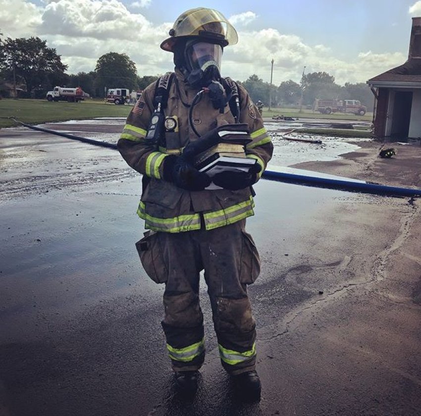 A firefighter holds a stack of bibles that were rescued from a fire that destroyed the The Lighthouse Tabernacle Church in Crothersville, Indiana on June 3, 2018.