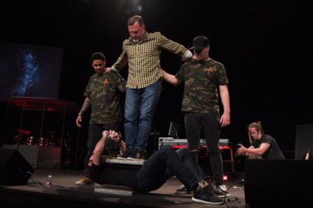 Strongman Stephen Miller is sandwiched between two beds of nails as his father, world-renowned Strongman Steve Miller stands on top of the beds during an appearance at The Fellowship of Texas City in April 2017.