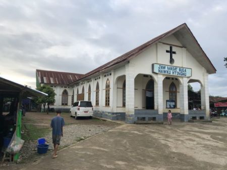 A man and child walk outside of a church in the Kachin state of Myanmar, where 95 percent of residents are Christian.