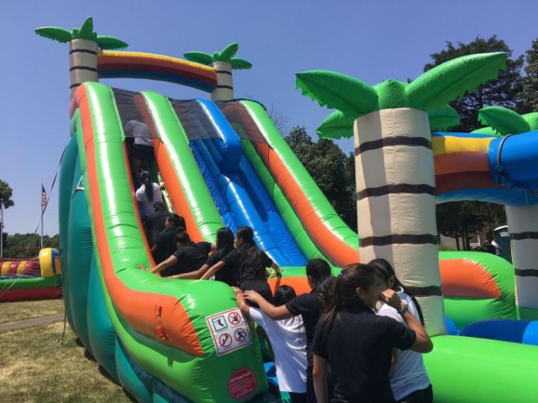 Immigrant children being cared for at the Youth for Tomorrow residential campus in Bristow, Virginia climb on an inflatable waterside on July 13, 2018.