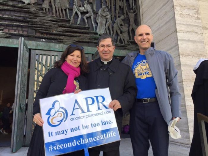 San Diego doctor George Delgado (R) is known as the face of the Abortion Pill Reversal Network. His wife Liz (R) and a member of the clergy (C) stand with him in this photo.