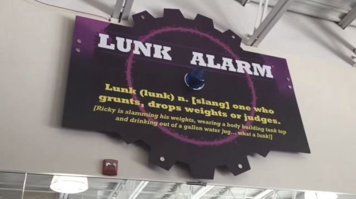 A 'Lunk Alarm' sign hangs in a Planet Fitness gym.