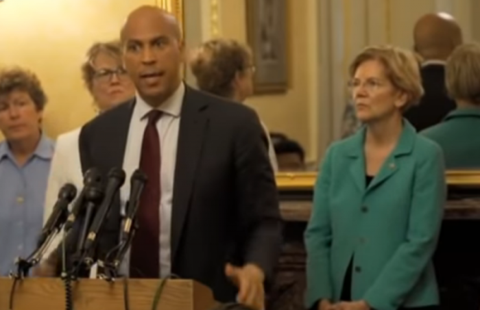 Sens. Cory Booker (and podium) and Elizabeth Warren (right) at a press conference on Capitol Hill, July 24, 2018.