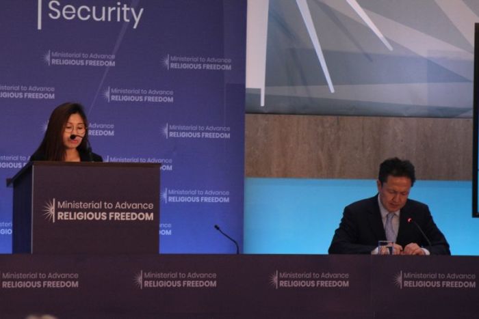 Ji Hyeona speaks during the State Department's first-ever Ministerial to Advance Religious Freedom in Washington, D.C. on July 24, 2018, with a translator sitting to her left.