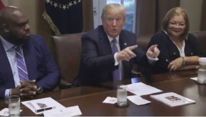 President Donald Trump speaks with a group of black Christian leaders at the White House on Aug. 1, 2018. He is seated next to megachurch pastor John Gray (L) and Alveda King (R).