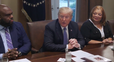 President Donald Trump speaks with a group of black Christian leaders at the White House on Aug. 1, 2018. He is seated next to megachurch pastor John Gray (L) and Alveda King (R).
