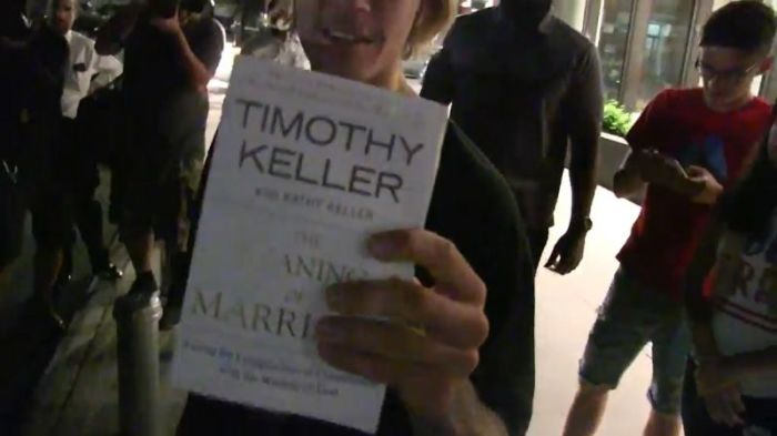 Justin Bieber holding up Tim Keller's 'The Meaning of Marriage' book in New York City on August 8, 2018.