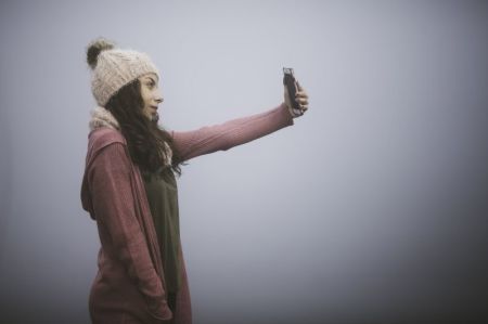 A woman takes a "selfie" picture with her cell phone.