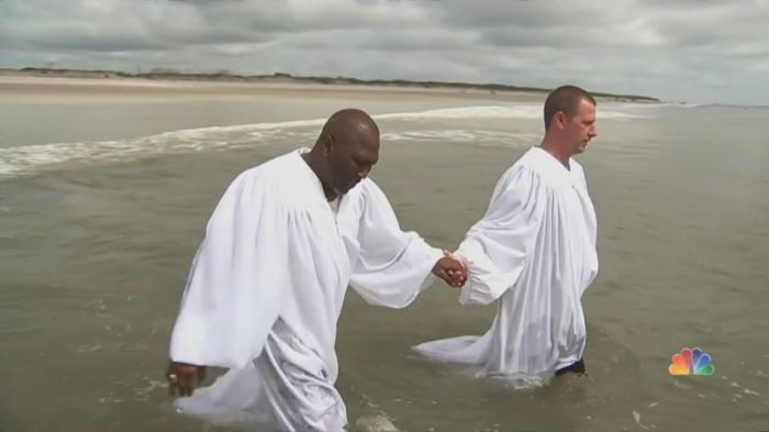 Former KKK grand dragon Ken Parker (R) being baptized in the Atlantic Ocean in July 2018.