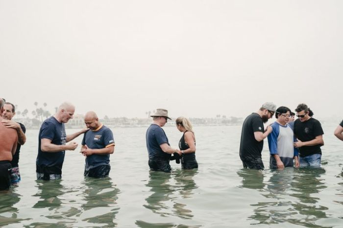 People are praying during a mass baptism at Pirates Cove Beach in Newport Beach, California on Sept. 8, 2018. The mass baptism was organized by Greg Laurie's Harvest Christian Fellowship.