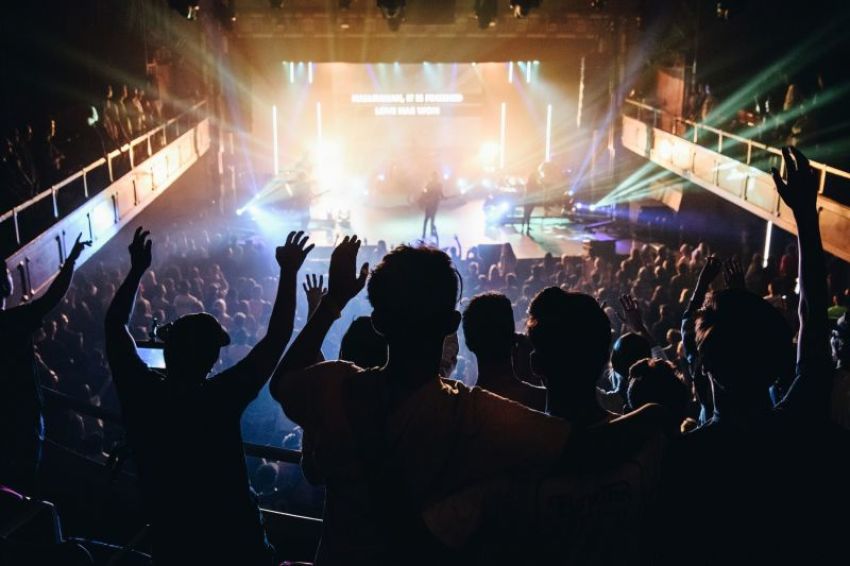 High school students at a Christ in Youth "Move" conference at Chapman University in Southern California raise their hands in worship.