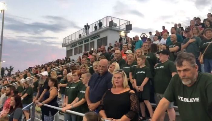 Attendees of a football game at Locust Fork High School in Locust Fork, Alabama, recite the Lord's Prayer as they wear 'We Believe' T-shirts in response to a the Blount County School District banning prayer over the loudspeaker before games on Sept. 21, 2018.