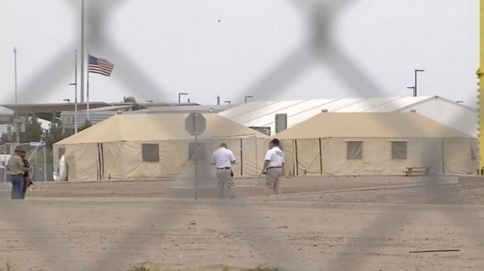 Police officials stand outside at a tent city for migrant children in Tornillo, Texas.