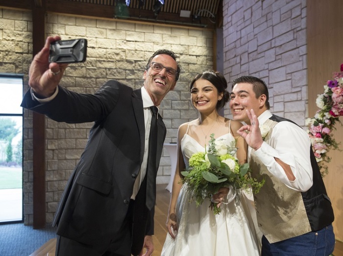 Senior Pastor Pete Briscoe (L) of Bent Tree Bible Fellowship church takes a selfie with newlyweds Leandra Hernandez and Dale Frey at the church in Texas on September 29, 2018.