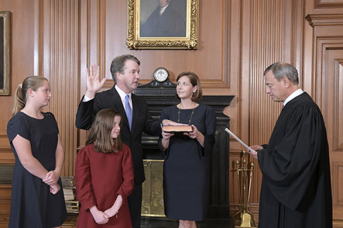 Chief Justice John G. Roberts, Jr., administers the Constitutional Oath to Judge Brett M. Kavanaugh in the Justices' Conference Room, Supreme Court Building. Mrs. Ashley Kavanaugh holds the Bible.