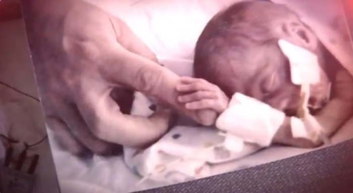 Charlotte Ryun, born at 22 weeks, grabs her father's finger.