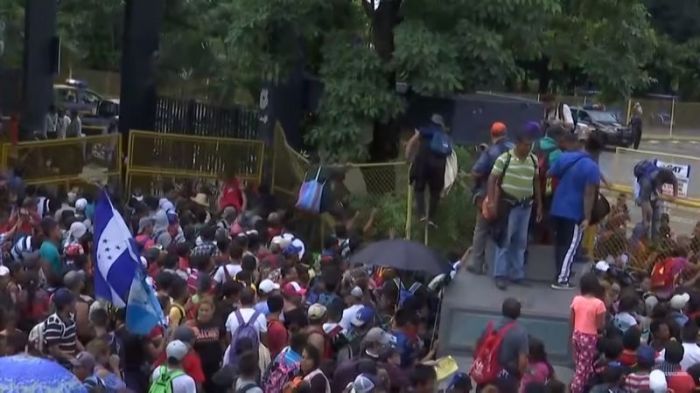 Honduras migrants breaking through the border wall with Mexico in a video published October 19, 2018.
