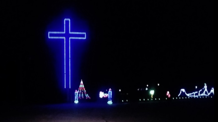 A blue-lit cross stands erect as part of a Christmas light display at Finley River Park in Ozark, Missouri in December 2018. 