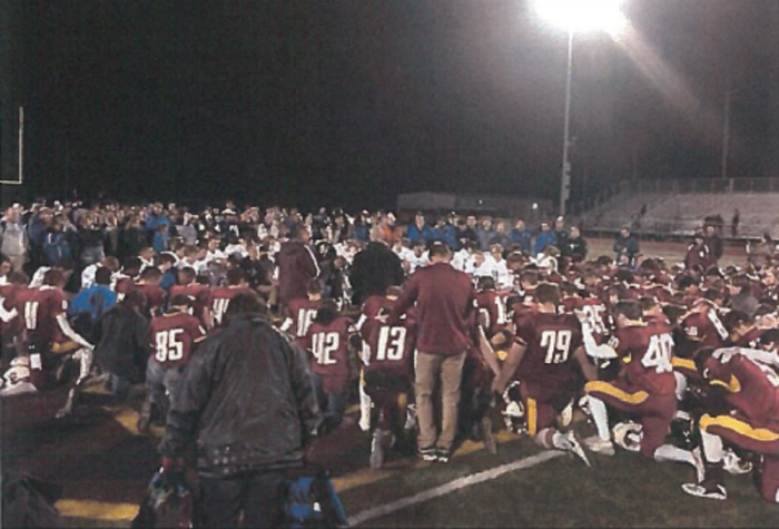 Coaches and players from Gibson Southern High School and Reitz Memorial High School pray on the field after their game on Nov. 2 in Fort Branch, Indiana. 