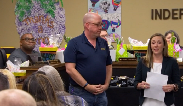 Adi Bryant (R), Royse City Independent School District's chief communications officer in Texas, recognizes Royse City UMC Pastor Chris Everson, for leading his church into paying of the lunch debt for more than 200 students in the district. | Screenshot: NBC 5