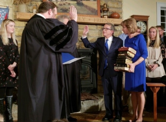 Ohio Gov. Mike DeWine takes his oath of office on a stack of nine bibles at his home in Cedarville on Jan. 14, 2019. 