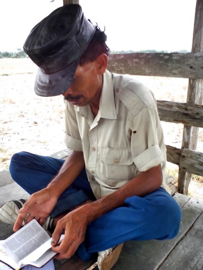 A new believer in Southeast Asia reads from Scripture in 2014.