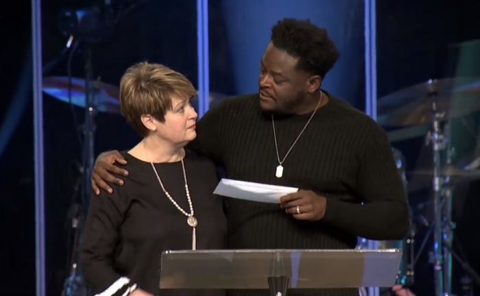 Transformation Church Pastor Derwin Gray (R) gives a donation to Julie Walters (L), executive director of the Women's Enrichment Center in Lancaster, South Carolina, during a church service on Feb. 10, 2019. 