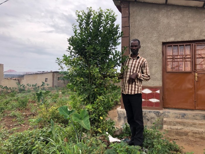 Emmanuel Ndayisaba poses by the lemon tree he planted at the house of Alice Mukarurinda in Nyamata, Rwanda on Feb. 18, 2019. The plant signifies the forgiveness he received for attacking Mukarurinda and her family on April 29, 1994, during the Rwanda genocide. 
