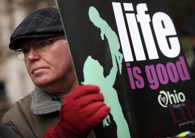 Pro-life activist Brian Normile of Beavercreek, Ohio, holds up a poster during a prayer vigil outside Planned Parenthood January 21, 2014 in Washington, DC. 
