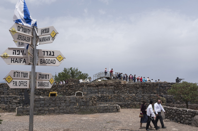 Ultra Orthodox Jews and tourists gather next to signs pointing out distances to different cities on Mount Bental next to the Syrian border in the Israeli-annexed Golan Heights on May 10, 2018. 