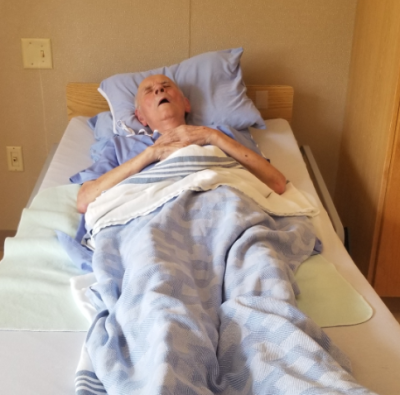 Randal Rauser's dad, who has Alzheimer’s disease, lies in bed.
