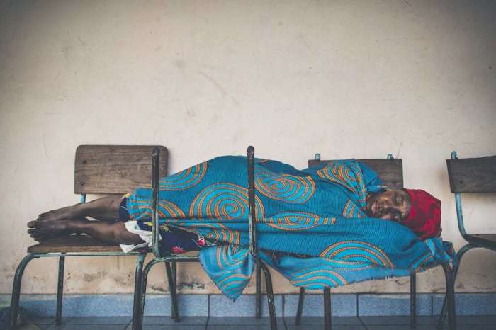 A woman sleeps on chairs at Dondo Secondary School in Dondo, Mozambique (outside of Beira), which was heavily damaged by Cyclone Idai. The school was converted into temporary shelter.