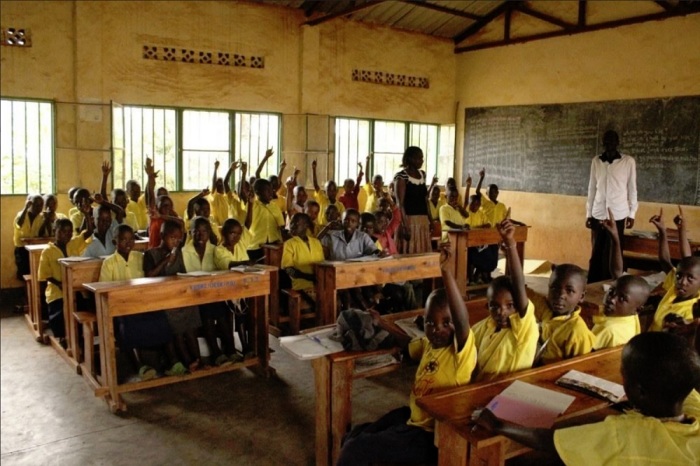 Rwandan school children raise their hands when asked how many of them are sponsored by World Vision. 