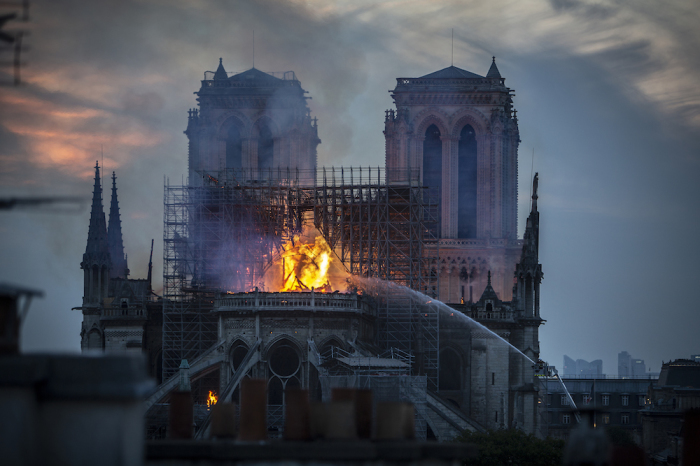 Smoke and flames rise from Notre-Dame Cathedral on April 15, 2019 in Paris, France. A fire broke out on Monday afternoon and quickly spread across the building, collapsing the spire. The cause is yet unknown but officials said it was possibly linked to ongoing renovation work. 