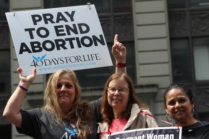 Abortion survivor Cindy Fiore (L) stands with Ann Migliore (C) and another supporter at the 'Alive From New York' event hosted by Focus on the Family in Times Square New York City on May 4, 2019.