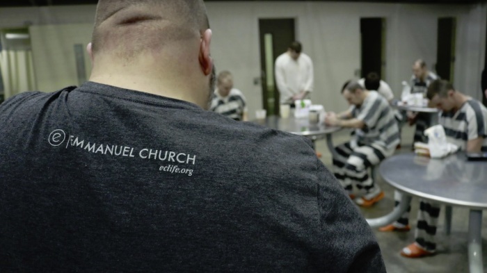 Inmates at Brown County Jail in Indiana pray after receiving care kits given to them by Emmanuel Church. 