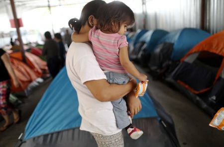 A Honduran mother holds one of her two daughters in the migrant shelter where they were living near the U.S.-Mexico border on April 4, 2019 in Tijuana, Mexico.