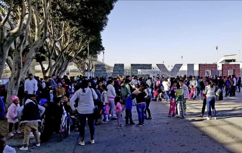 Migrants and asylum seekers gather outside near the U.S.-Mexico border in Tijuana, Mexico.