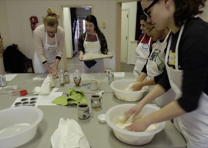 Young adults participate in Rise, a break baking workshop sponsored by St. Mark's Parish in Philadelphia, Pennsylvania. It meets in an abandoned Episcopal church building and seeks to gather young adults ages 21-35 around the baking of bread. It offers stimulating presentations and activities during the bread's rise time.